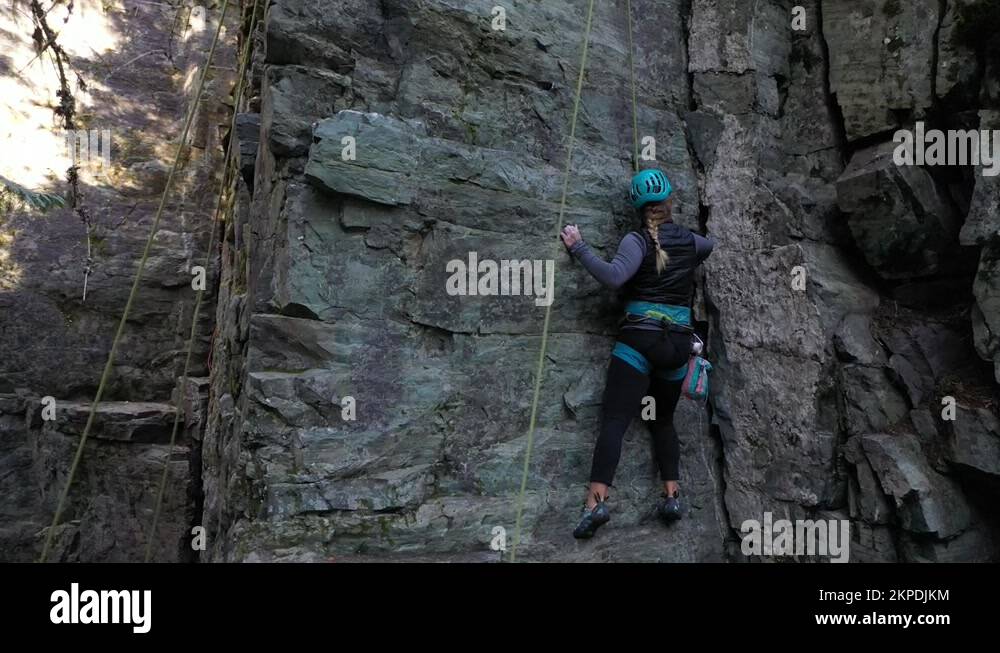 Adventurous Woman In Safety Gear Climbing On A Crag. Rock Climbing