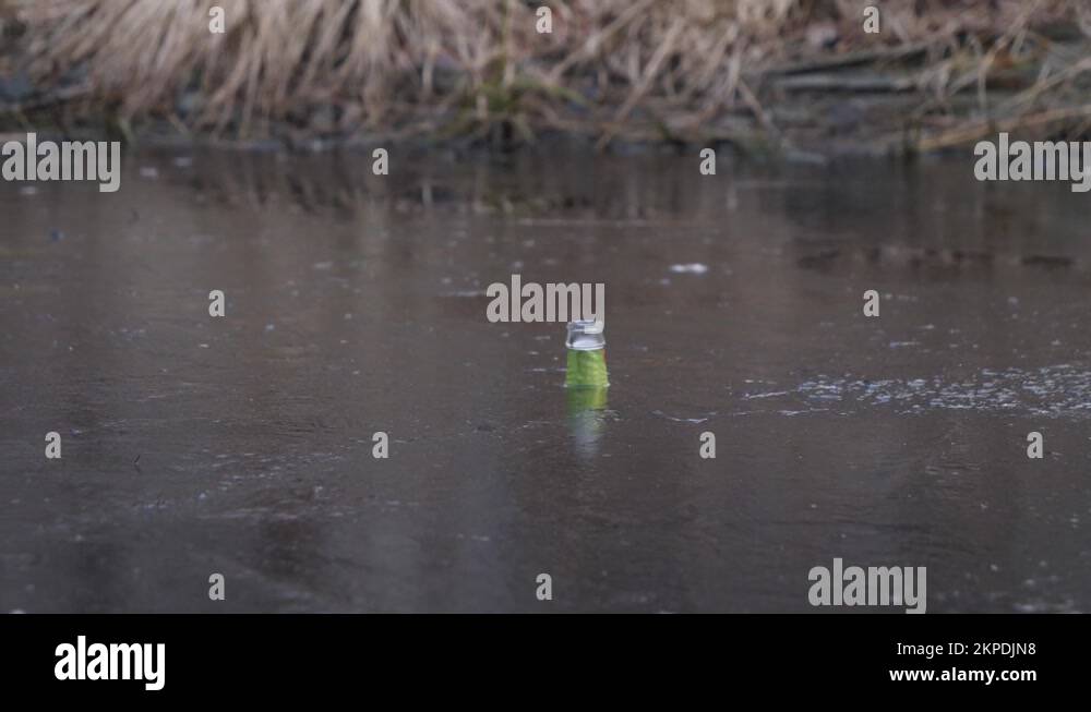 Glass Bottle Stuck in Ice, Water Pollution and Trash in Nature at