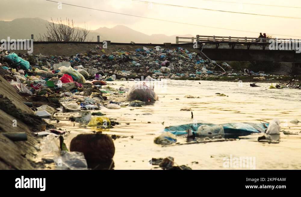Dirty polluted river bank with plastic trash in Southeast Asia. Locals ...