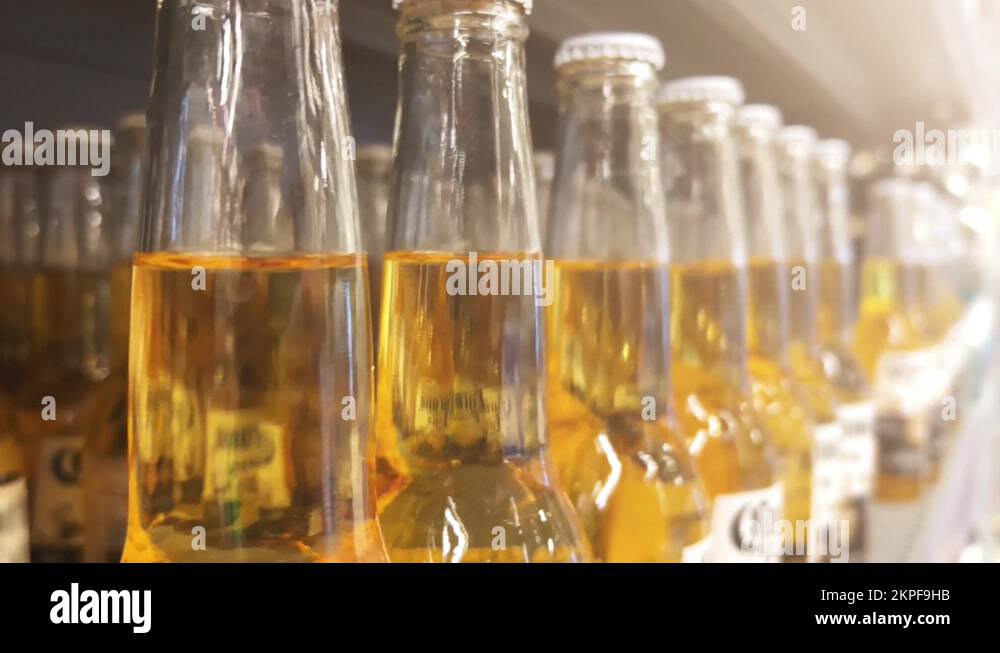 Light beer in glass bottles on the shelves of a supermarket or liquor