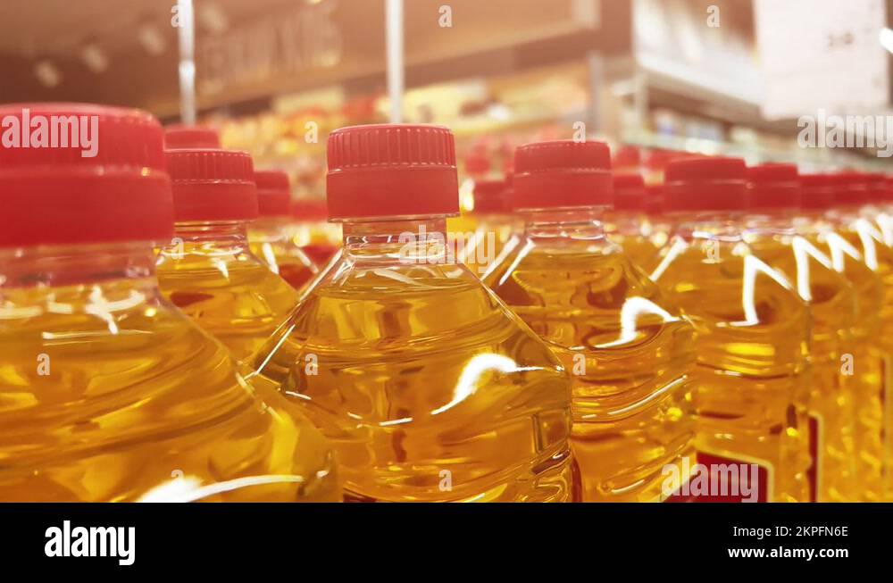 Sunflower or corn oil in plastic bottles line up on the shelf in a