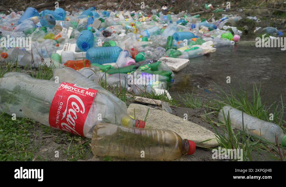 CLOSE UP Ironic text on plastic Coca Cola bottle near waste pollution
