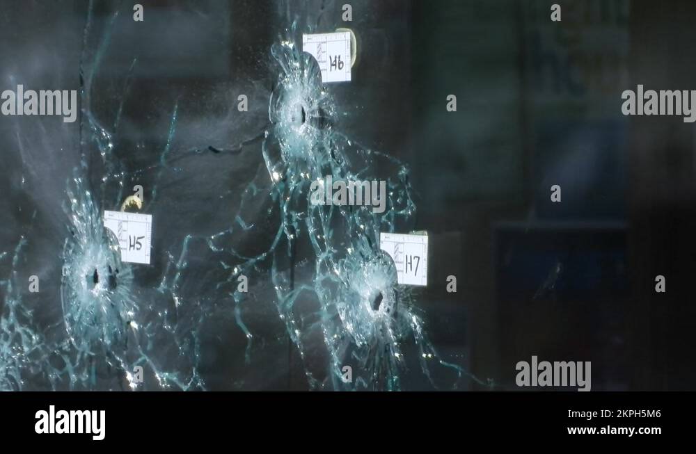 Bullet Riddled Square Evidence markers indicate Bullet holes riddled the front window of Tops ...