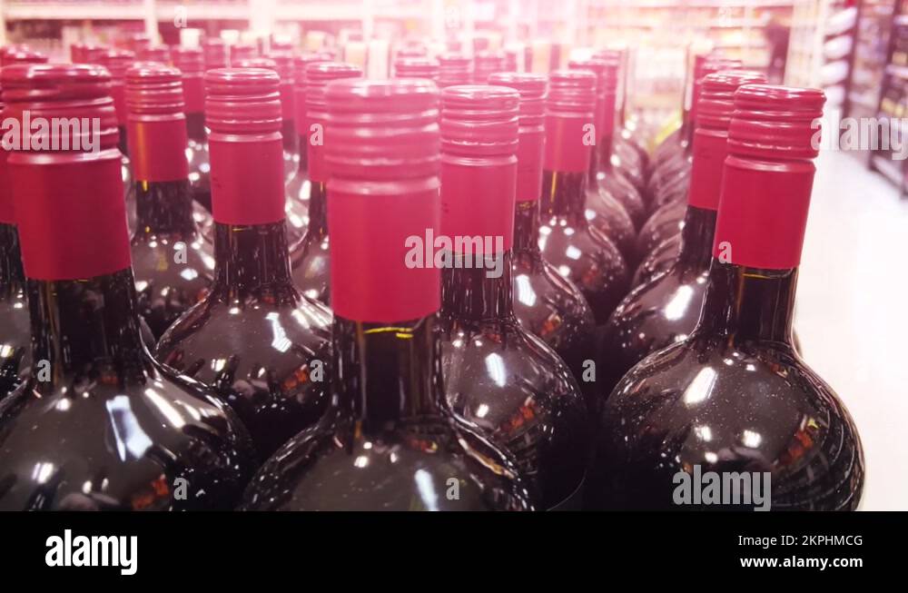 Red wine bottles stand on the shelves of a liquor store (ABC) or