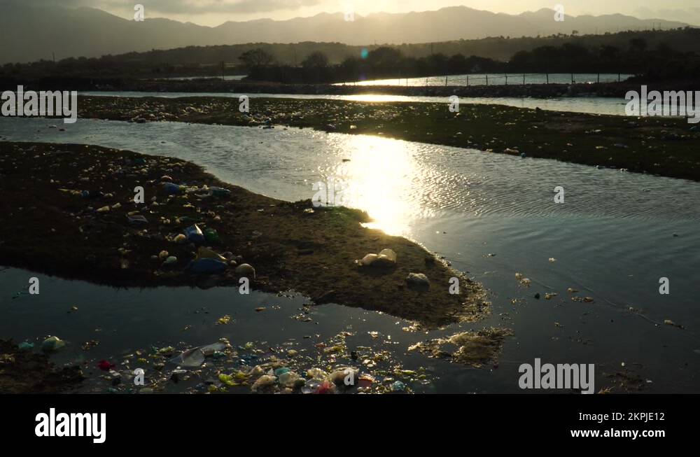 polluted area with sunset water reflection and plastic waste toxic