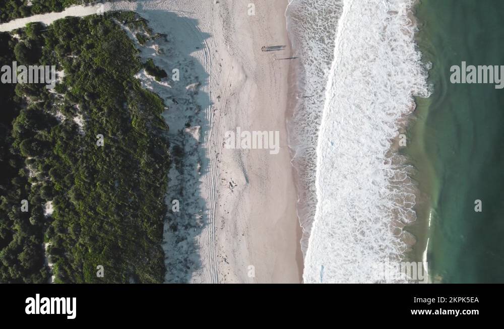 Moving Birdseye overview of Magenta Beach as the waves crash on the