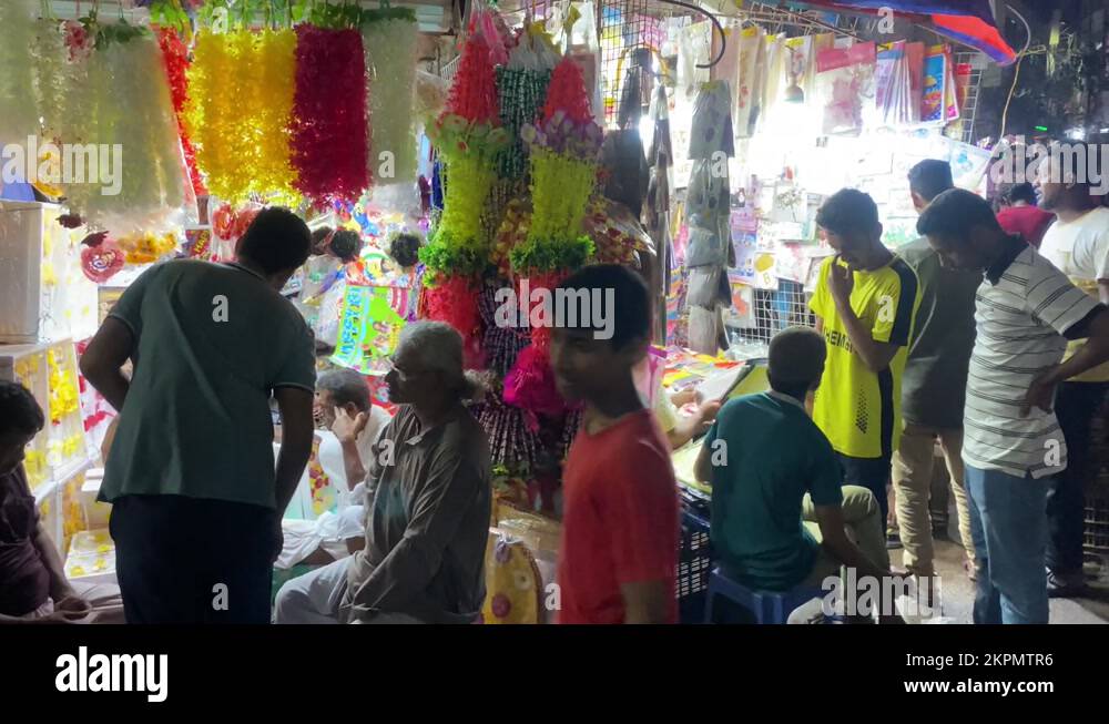 Locals Walking Past Night Time Bazaar Market Stalls In Dhaka. Slow Motion Stock Video Footage