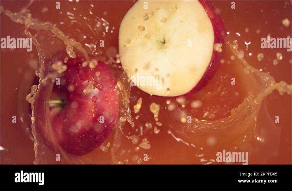 Red Apple falling on juice with splash and divided in half Stock Video