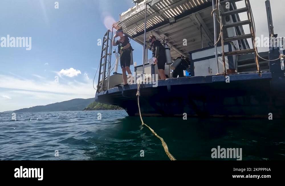 Female Scuba Diver Jumping Off Dive Boat In Koh Lipe. Low Angle Shot