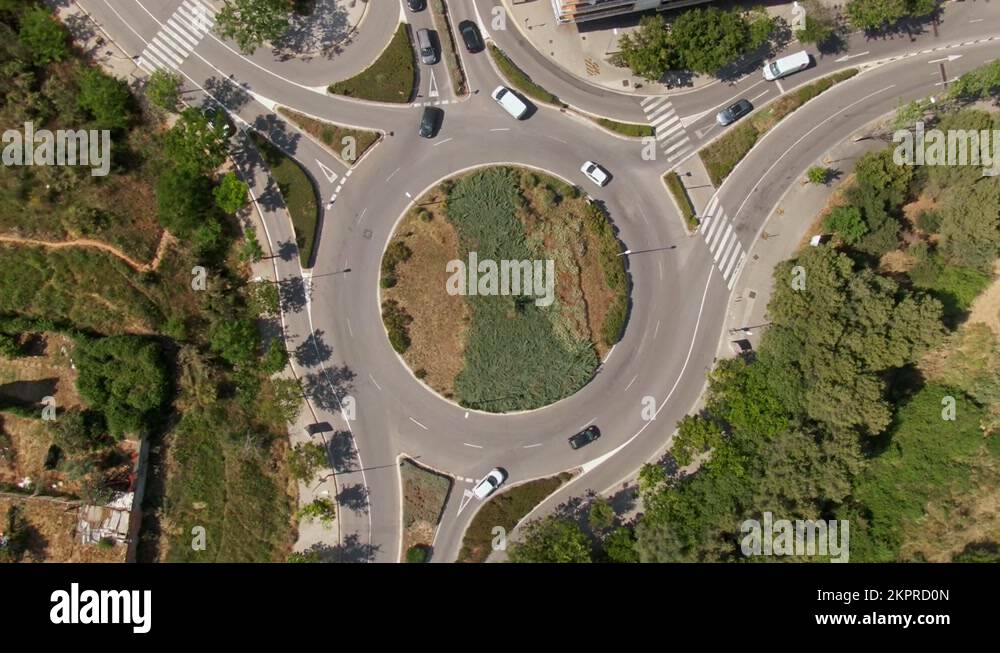 Suburban roundabout with driving vehicles in Spain, aerial top down