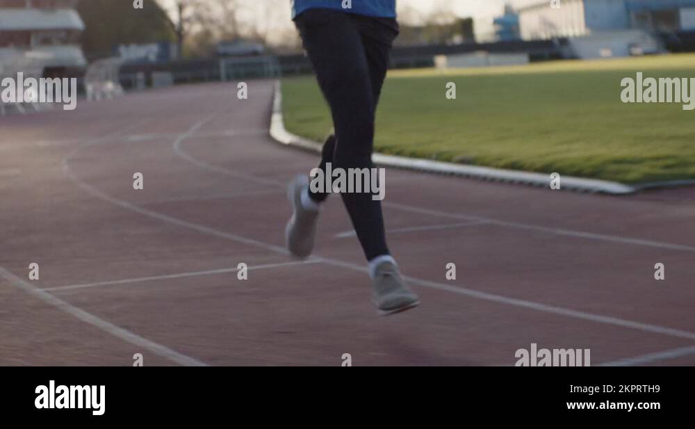 Cinematic panning shot of young black runner on the running track