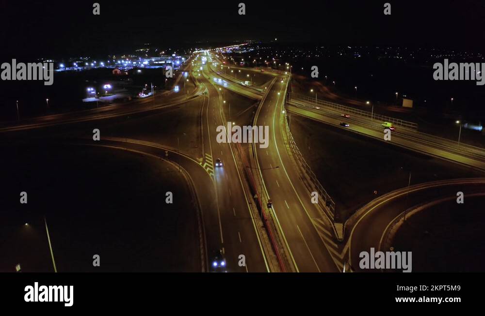 Drone shot on a night freeway with bridges and viaducts and car traffic ...