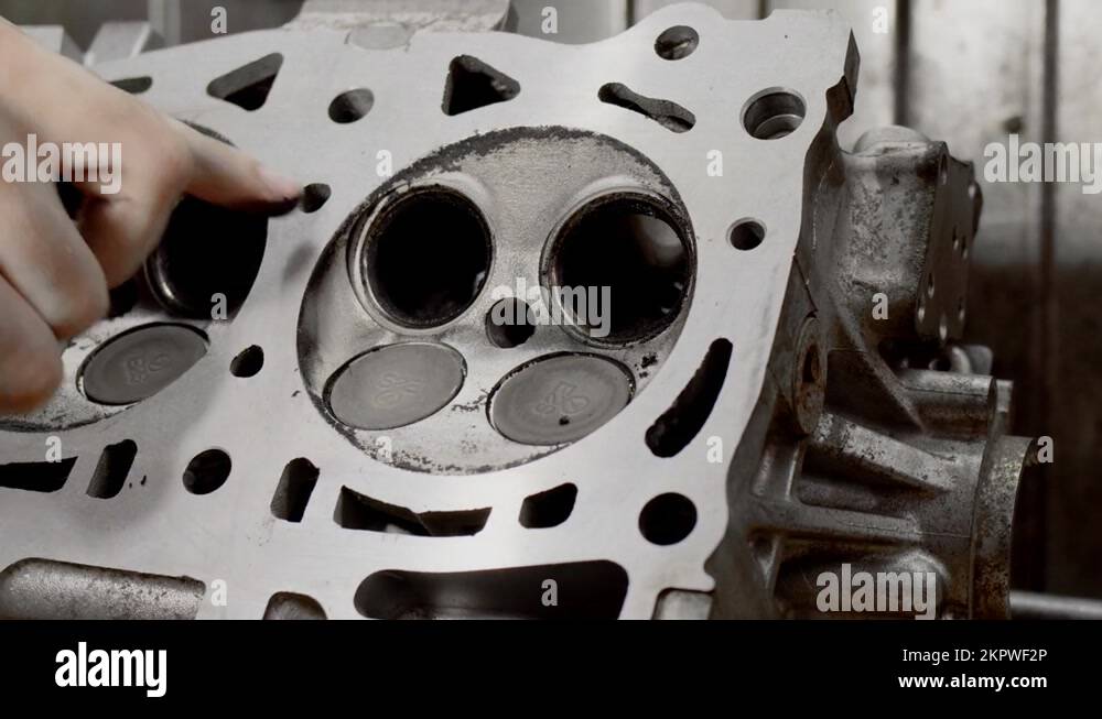 mechanic in car service took off valve head of engine and shows amount