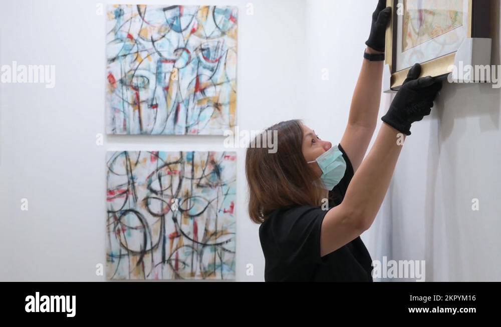 During the setup and installation day, art exhibitors place paintings