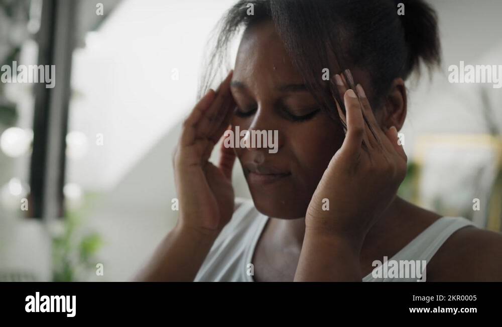 Close up of African American woman with huge headache standing in the