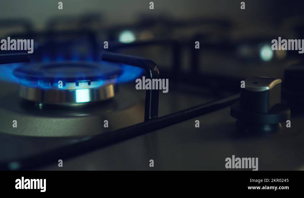 Kitchen gas stove fire inflaming. Blue flame switch off by woman hand