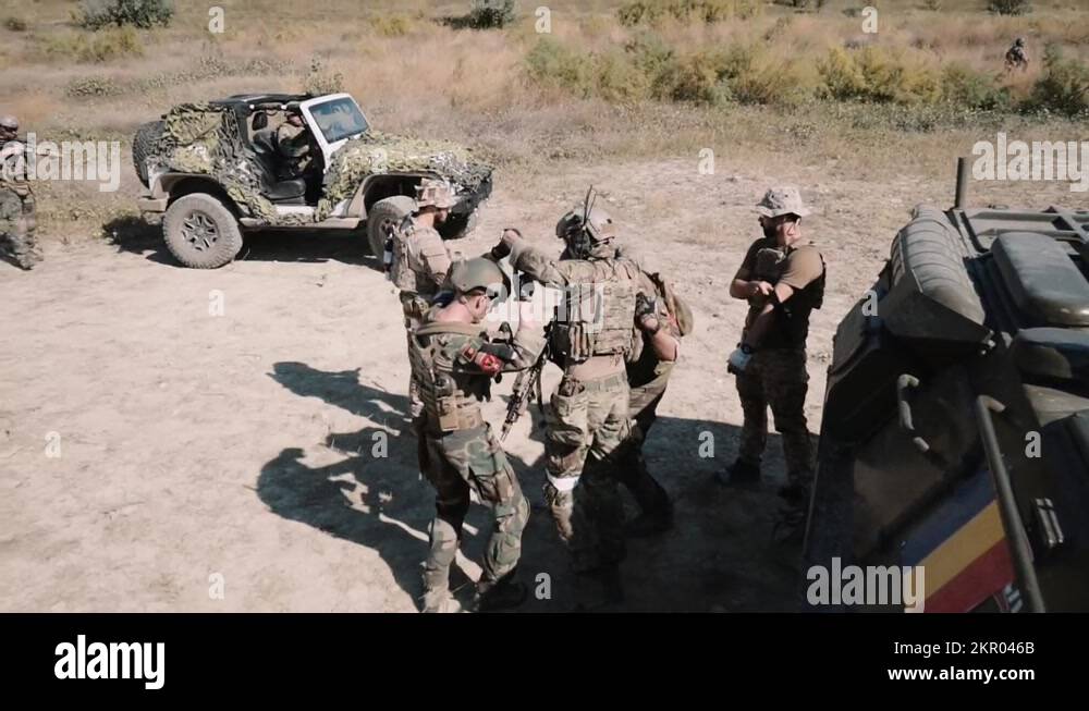 U.S. Navy SEALS carry under the arms of a wounded soldier Stock Video