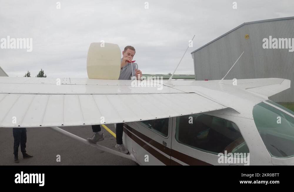 Pilot Measures Fuel Of A Cessna Plane, Dipping Fuel Stick Into Fuel