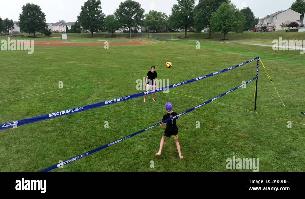 Teenage friends play volleyball outside on summer vacation. Aerial view