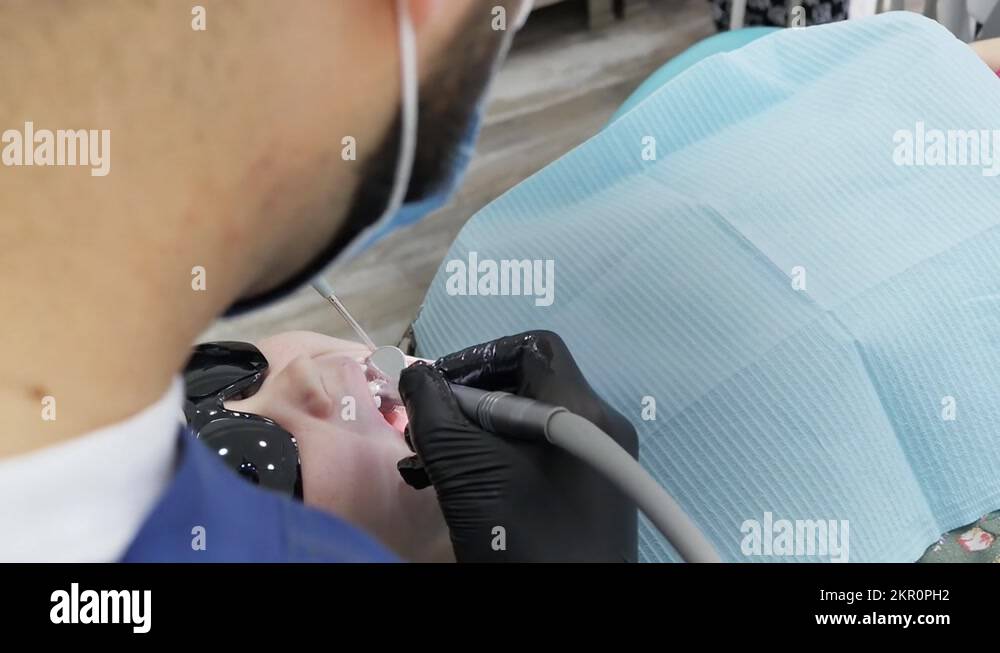 top view dentist drills a tooth in a little girl using a drill and a ...
