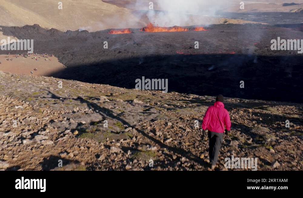 Guy walking on rugged hill overlooking natural phenomenon fissure ...