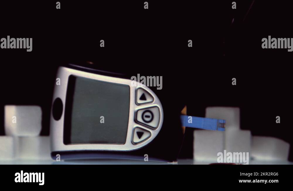 Drop of blood falling onto test strip of blood glucose monitor Stock