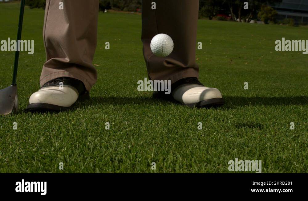 Golf ball falling beside golfers feet and club Stock Video Footage Alamy