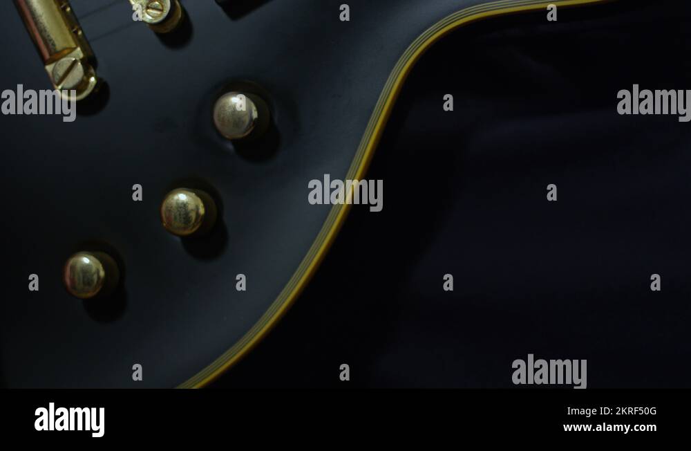 Musician turning volume and tone dials up and down on his black