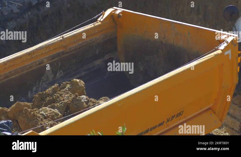 Dump truck being loaded with soil by hydraulic excavator. Timelapse, 4k