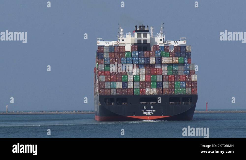 Rear of container ship Yang Ming Uniform, turning, navigating outbound ...