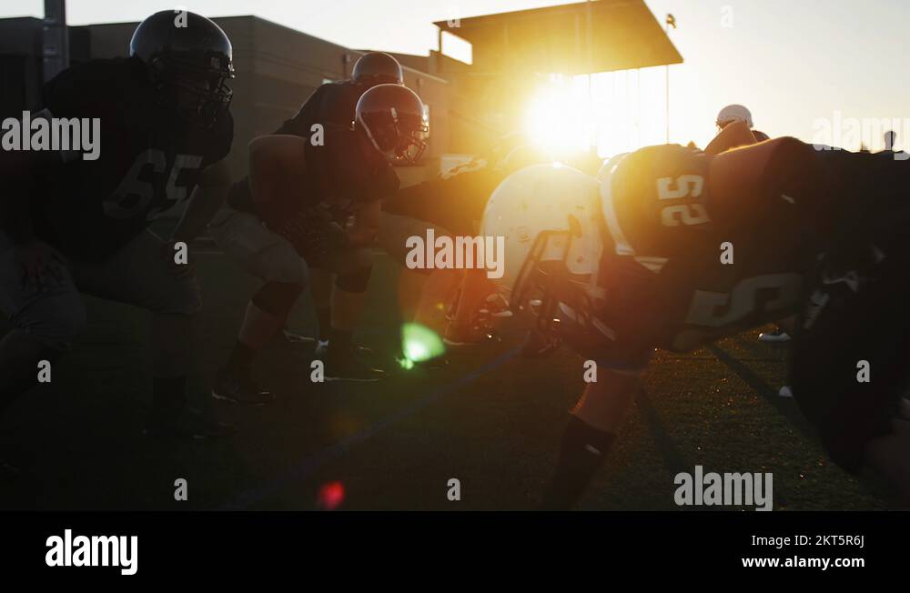 Two football players bump chests and high five after a good play Stock