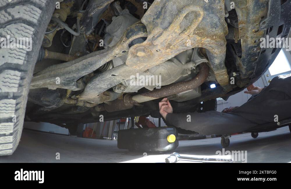 4k guy changes his oil under car Stock Video Footage Alamy