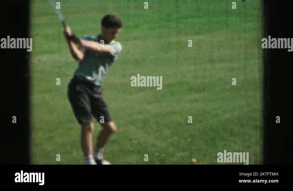 1968 Preteen boy hitting golf balls with driver club slow motion