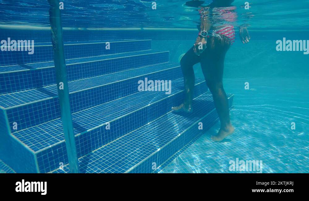Woman in a bikini walking underwater swimming pool steps Stock Video