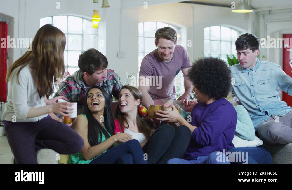 Excited group of young sports fans watching TV and spilling popcorn