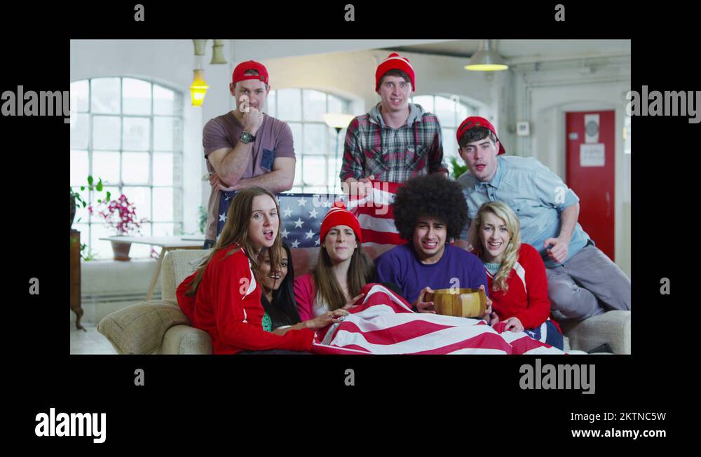 Excited group of young sports fans watching TV and spilling popcorn