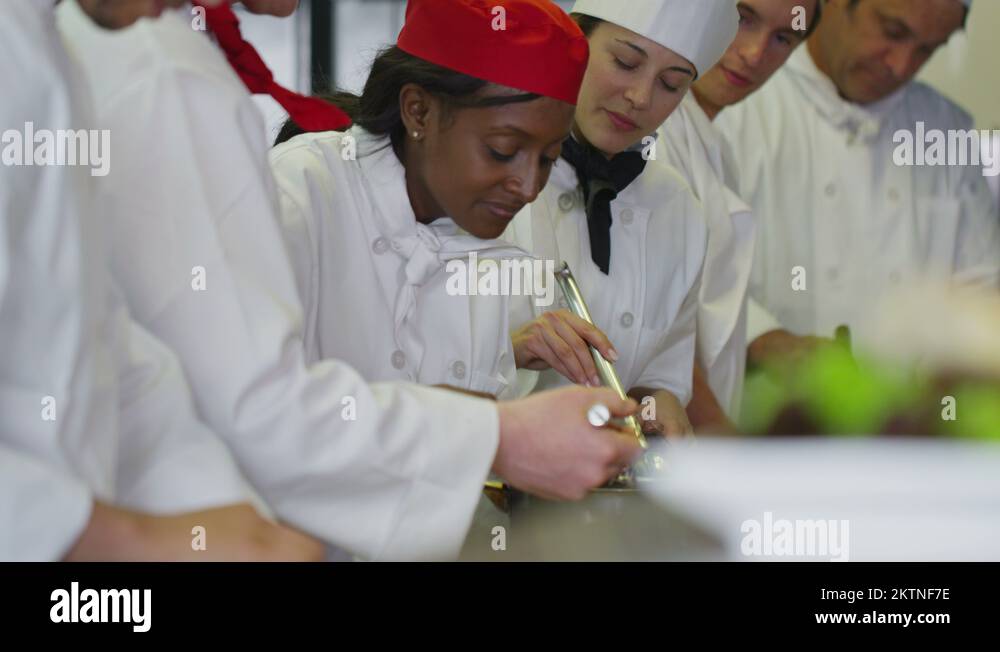 4K Happy team of chefs in a commercial kitchen, head chef tastes Stock Video Footage Alamy