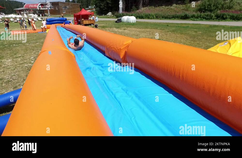 Enjoying the 300 metre long inflatable, water slide Stock Video Footage ...