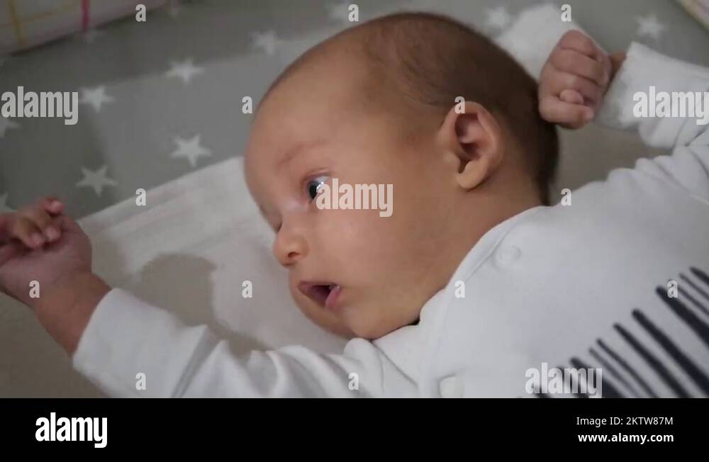 Baby in a crib. Camera moves away from child to mobile toy. Handheld
