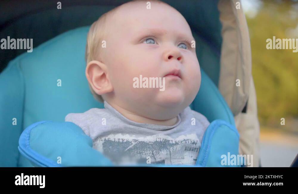 One years old baby boy sneezing in the pram. Closeup. Slow Motion