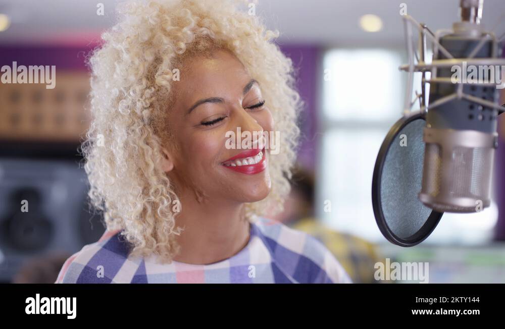 4K Portrait smiling female vocalist in recording studio standing at