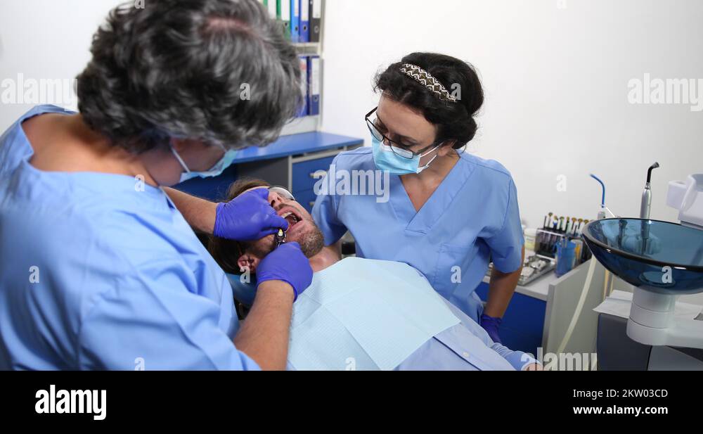 Dentist Man Extraction Surgery Pull Up Tooth to Patient Dental Medical