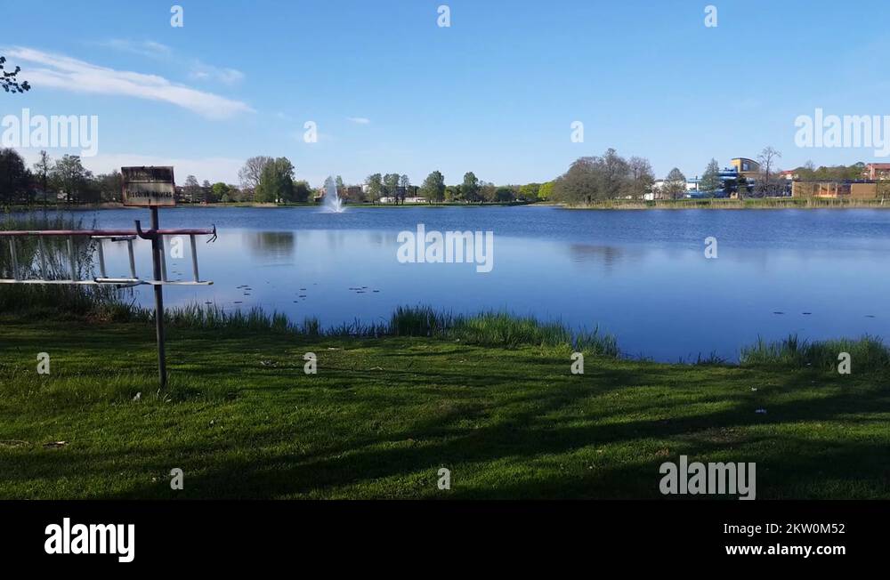 Left to right pan over a beautiful small lake in a park people