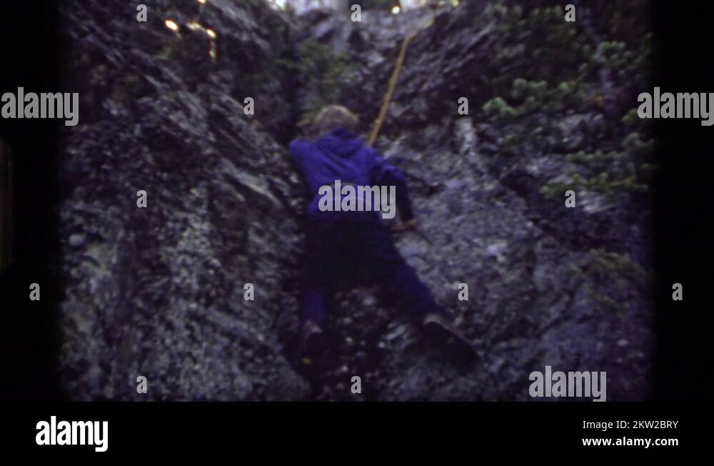 1977: boy rock climbing with rope tied around waist SAPPHIRE LAKE ...