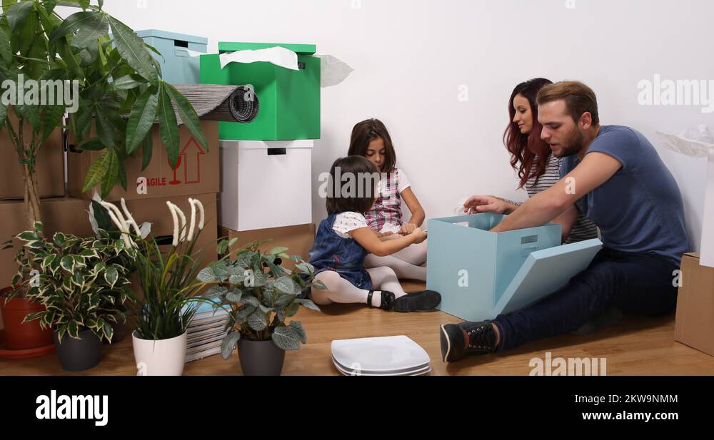 Beautiful Young Family Sits Down Packing Plates Fragile Pottery Moving
