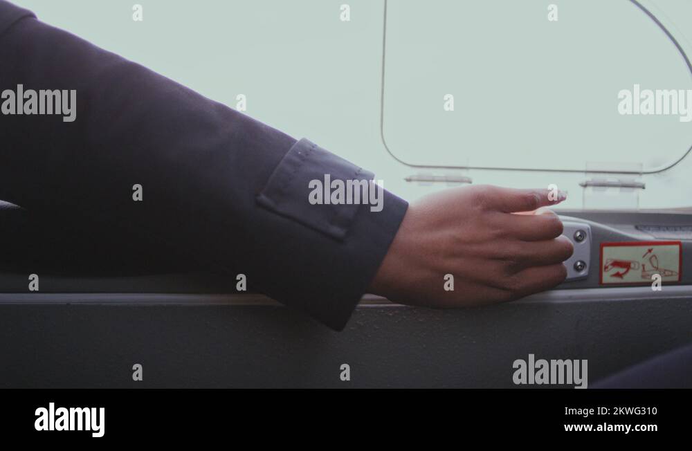 Woman hand open door lock in airplane. Unlock door inside airplane