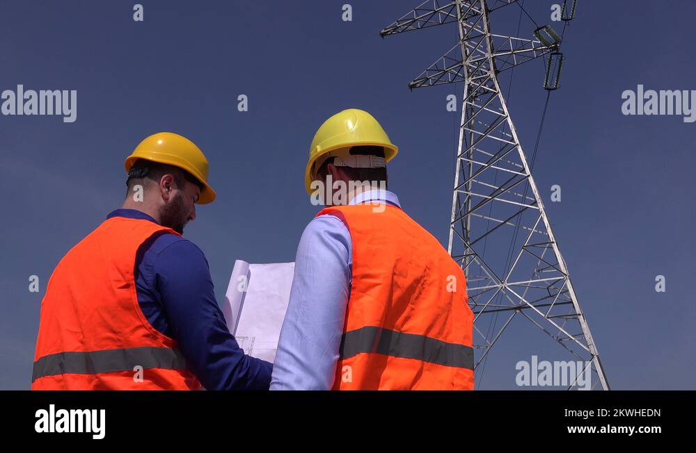 Engineering team engineers working at electricity tower outdoors