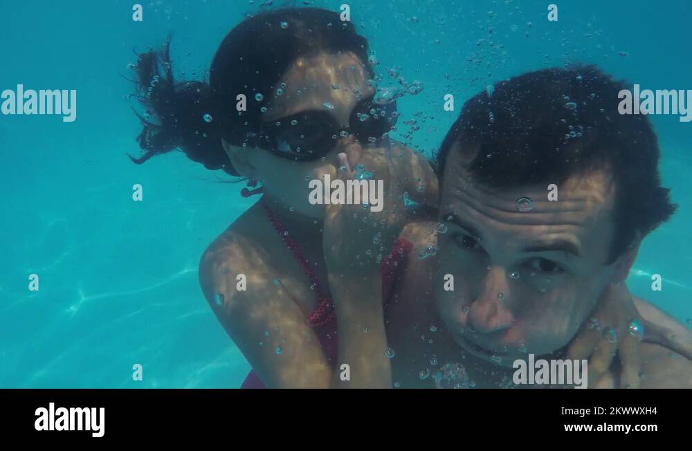 Dad and daughter in the pool underwater. man and girl teenager bathe in