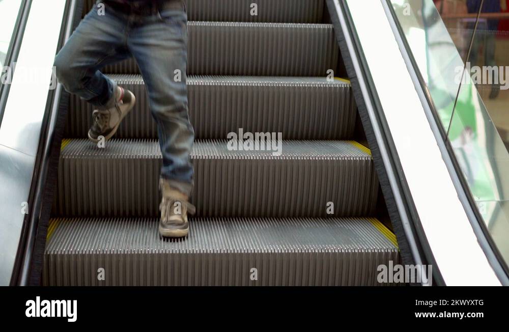 Little boy rises on the escalator. The boy goes down on escalator steps