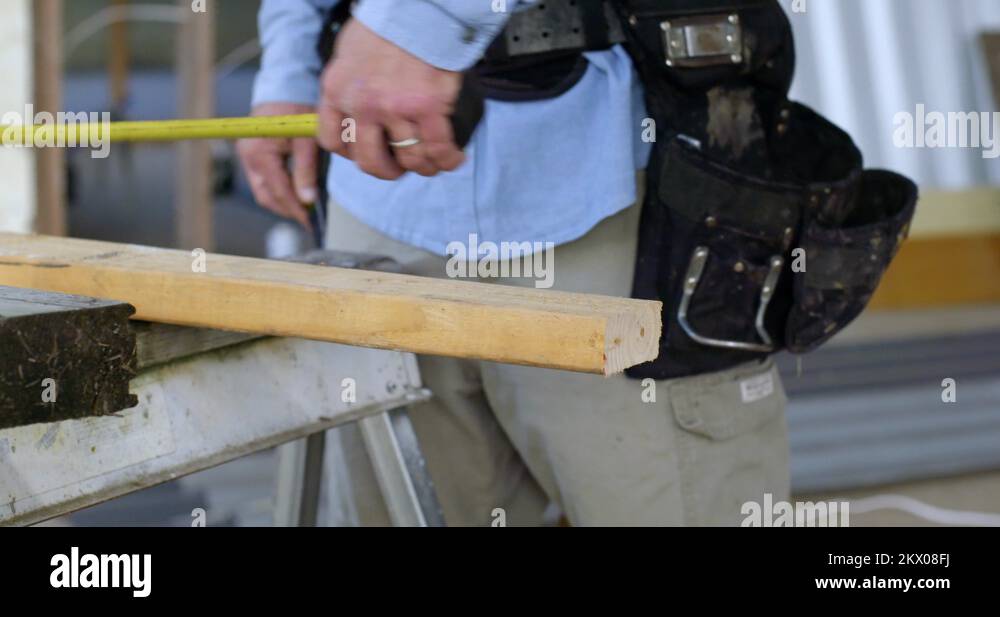 Contractor measures and marks a plank of wood in slow motion 4K Stock